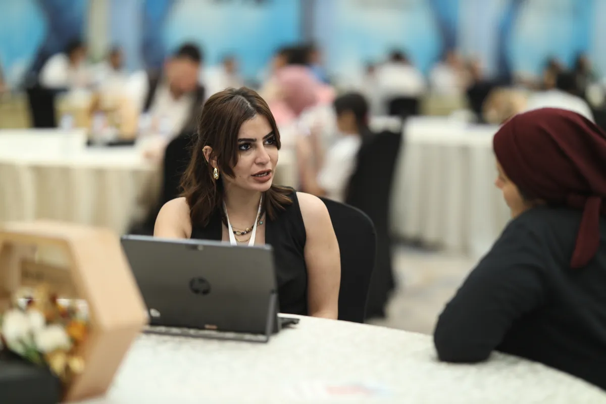 مستشارة تعرض تفاصيل مشروع عقاري لإحدى الزائرات على الشاشة